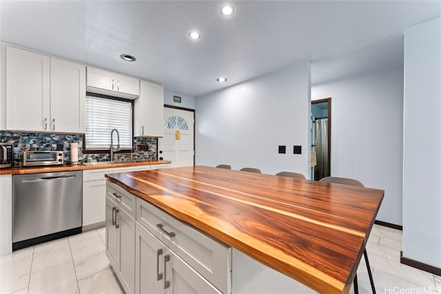 kitchen with dishwasher, sink, white cabinets, and wood counters