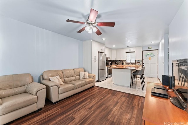 living room with sink, hardwood / wood-style floors, and ceiling fan