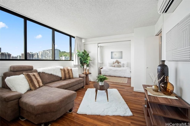 living room featuring a wall mounted AC, hardwood / wood-style floors, and a textured ceiling