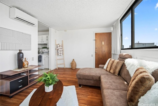 living room featuring wood-type flooring, an AC wall unit, and a textured ceiling