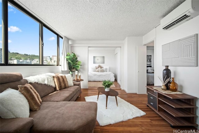 living room featuring a textured ceiling, wood-type flooring, and a wall mounted AC