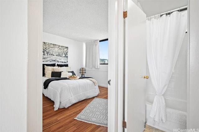 bedroom with wood-type flooring and a textured ceiling