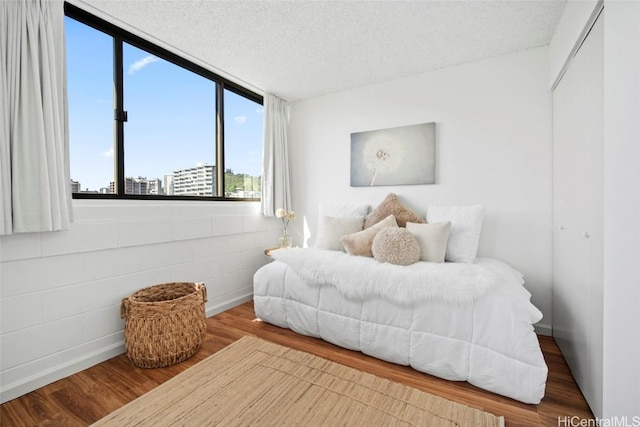 bedroom featuring hardwood / wood-style flooring and a textured ceiling