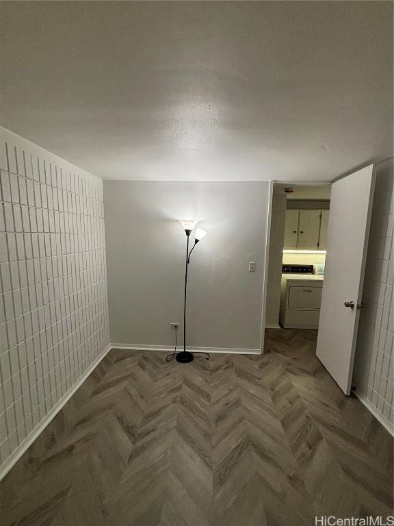 empty room featuring washer / clothes dryer and parquet floors