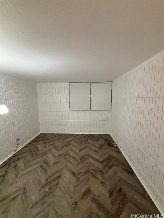 unfurnished room with dark parquet flooring