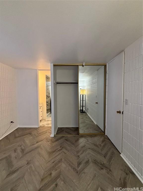 empty room with parquet floors and tile walls