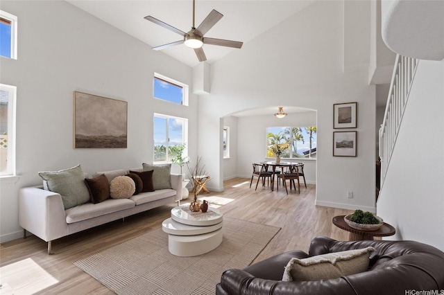 92-6012 Kohi St, Kapolei, HI 96707 - living area featuring ceiling fan, arched walkways, stairs, a high ceiling, and light wood finished floors