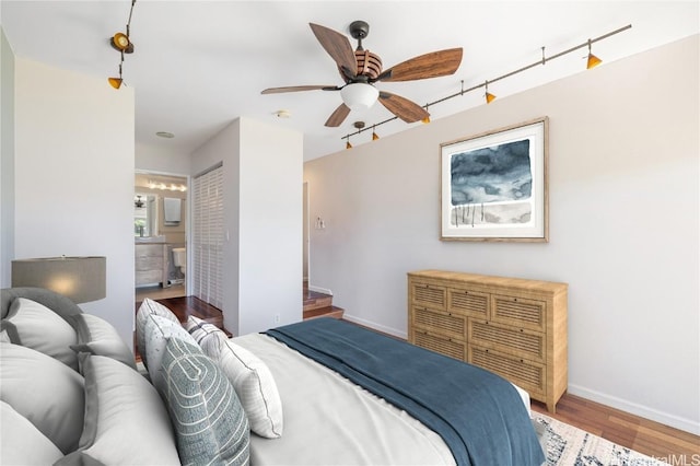 bedroom with ensuite bath, wood-type flooring, and ceiling fan