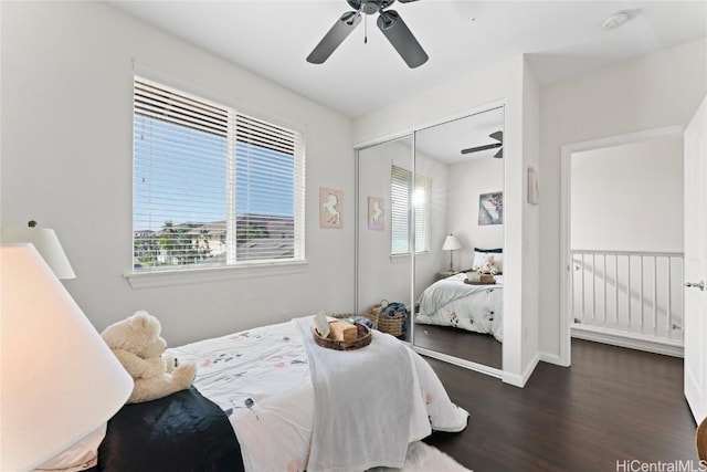 bedroom with a closet, ceiling fan, baseboards, and wood finished floors