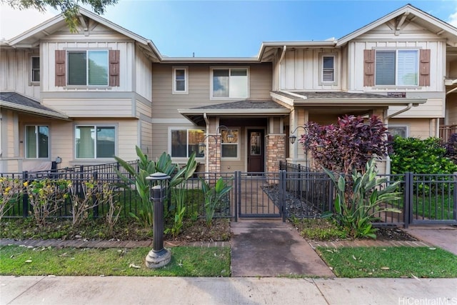 multi unit property featuring board and batten siding, a gate, and a fenced front yard