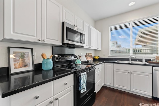 kitchen with appliances with stainless steel finishes, dark countertops, and a sink