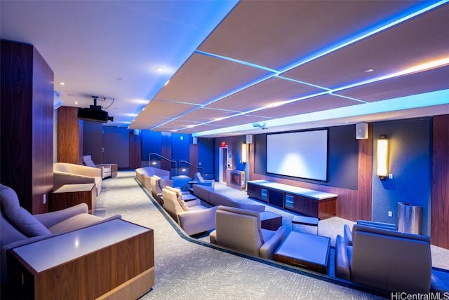 home theater room with carpet floors and wooden walls