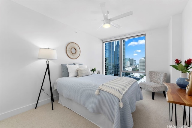 carpeted bedroom featuring ceiling fan and floor to ceiling windows