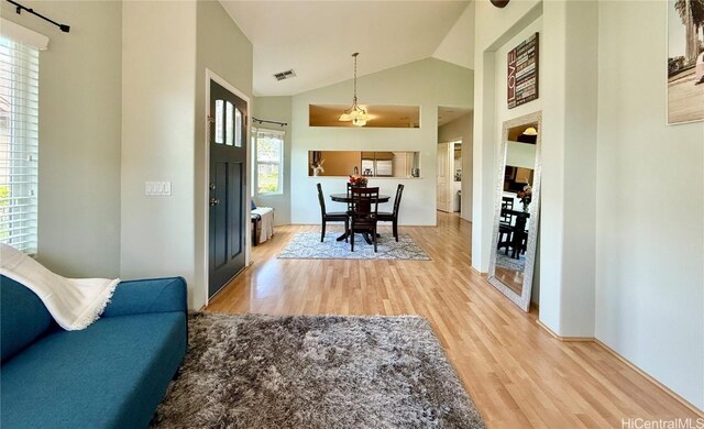 dining area with high vaulted ceiling and light hardwood / wood-style floors