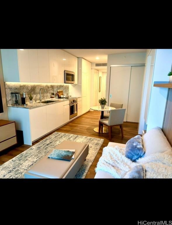 living room with sink and light wood-type flooring