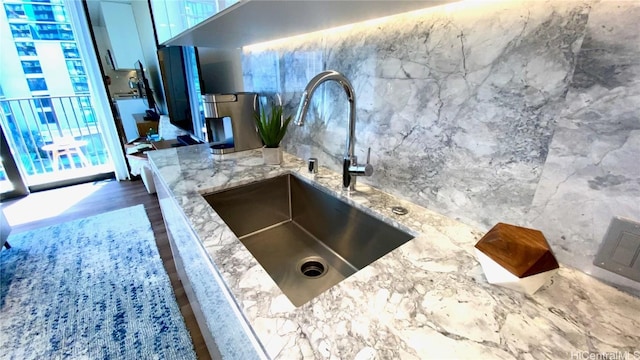 kitchen with light stone counters, sink, a wealth of natural light, and dark hardwood / wood-style floors