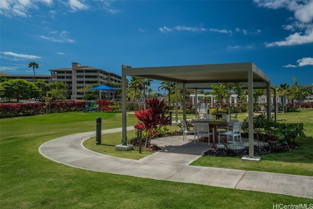 view of community with a playground, a patio area, and a lawn