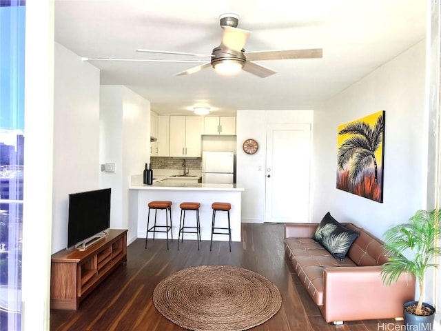 living room with dark wood-type flooring, ceiling fan, and sink