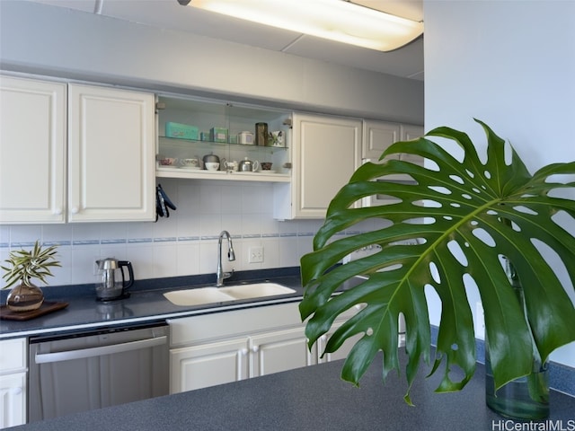 kitchen with sink, stainless steel dishwasher, white cabinets, and backsplash