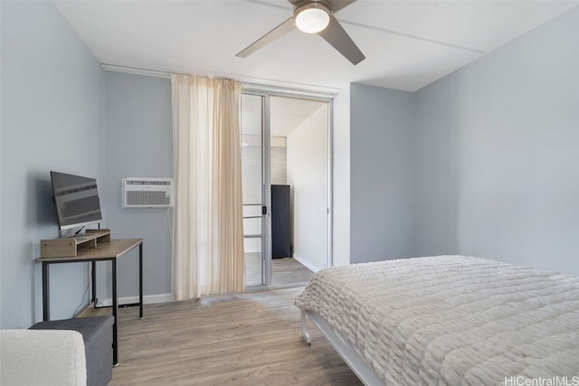 bedroom with a wall mounted air conditioner, ceiling fan, and light wood-type flooring