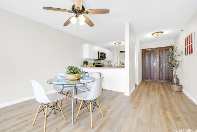 dining area featuring light wood-type flooring, ceiling fan, and baseboards