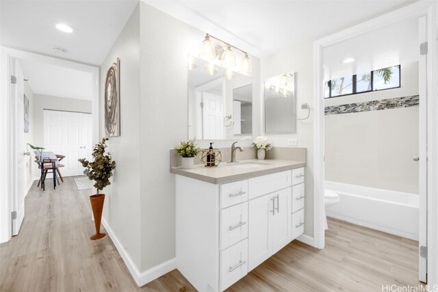 full bathroom with bathtub / shower combination, vanity, toilet, and wood-type flooring