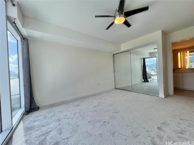 unfurnished bedroom with ceiling fan, a closet, and light carpet