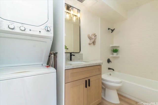 full bathroom with stacked washer and dryer, vanity, toilet, and shower / bathing tub combination