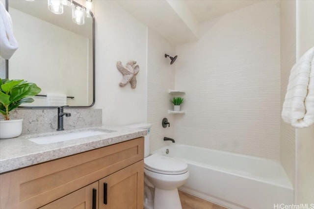 full bathroom featuring tiled shower / bath combo, vanity, and toilet