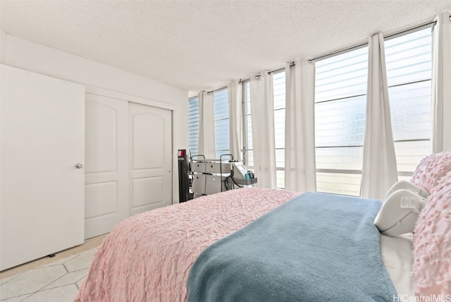 bedroom featuring multiple windows, a closet, and a textured ceiling