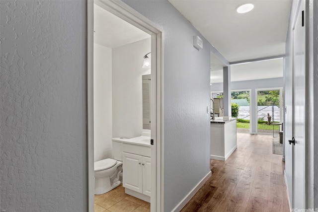 47-228 Hui Akikiki Pl Unit A/701, Kaneohe, HI 96744 - hall featuring a textured wall, baseboards, and light wood-style flooring