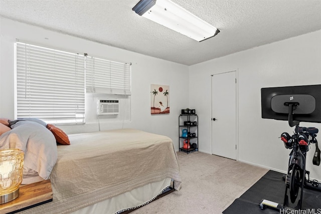 bedroom featuring a wall unit AC, a textured ceiling, and light colored carpet