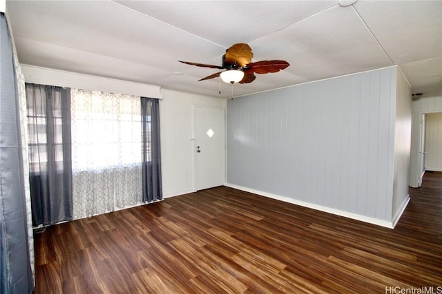 spare room with dark hardwood / wood-style flooring and ceiling fan