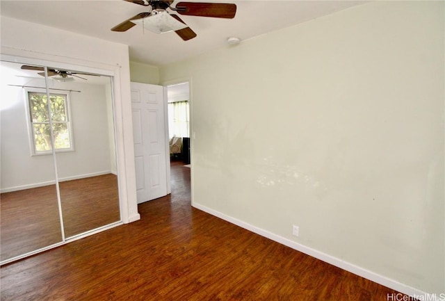 unfurnished bedroom featuring ceiling fan, dark hardwood / wood-style floors, and a closet