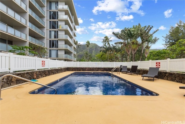 view of swimming pool with a mountain view and a patio area