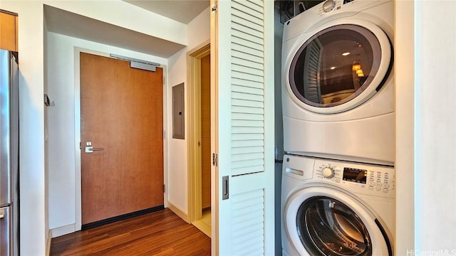 laundry area with stacked washer / dryer, dark hardwood / wood-style floors, and electric panel