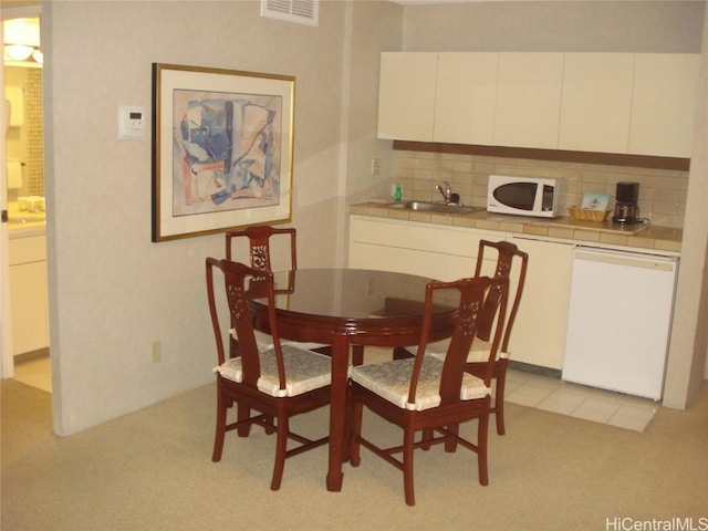 carpeted dining area with sink