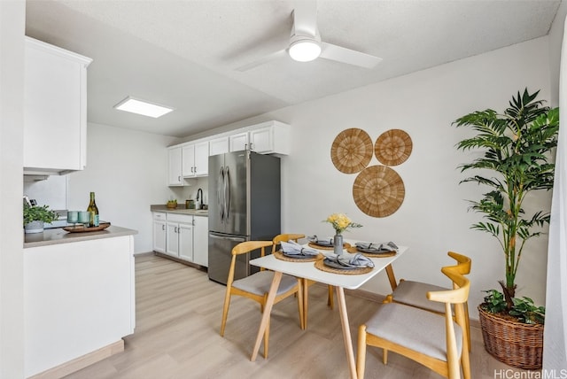 kitchen with white cabinetry, stainless steel fridge, ceiling fan, light hardwood / wood-style floors, and a textured ceiling