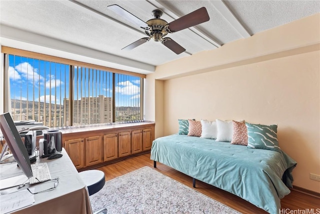 bedroom featuring ceiling fan, a textured ceiling, and light wood-type flooring