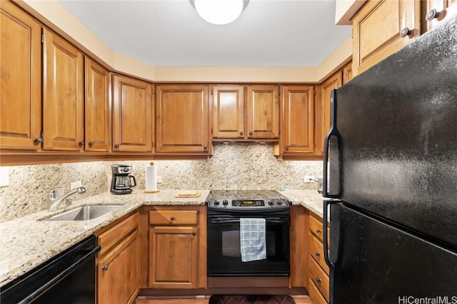 kitchen featuring light stone countertops, sink, decorative backsplash, and black appliances