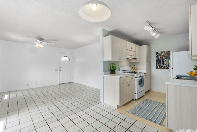 kitchen with white appliances, light tile patterned floors, rail lighting, a textured ceiling, and ceiling fan