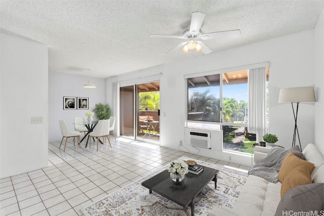 tiled living room with a wall mounted air conditioner, ceiling fan, and a textured ceiling