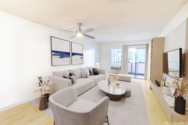 living room featuring ceiling fan, a textured ceiling, and light wood-type flooring