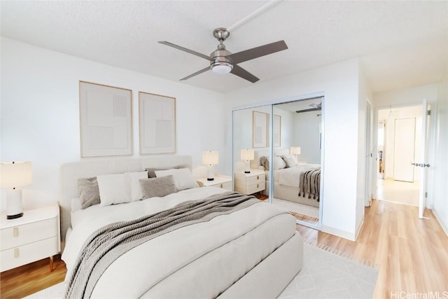 bedroom featuring ceiling fan, a closet, and light hardwood / wood-style flooring