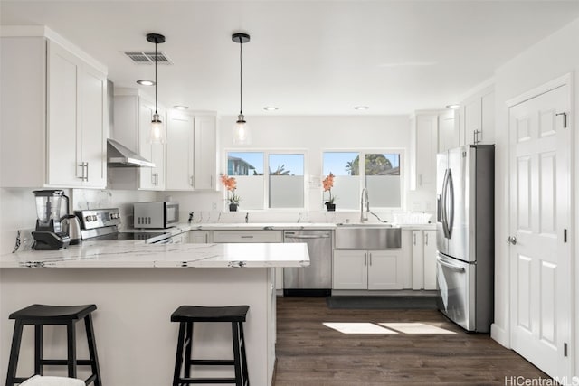 kitchen with sink, stainless steel appliances, kitchen peninsula, and white cabinets