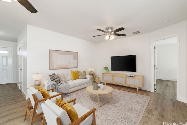 living room with light hardwood / wood-style flooring and ceiling fan