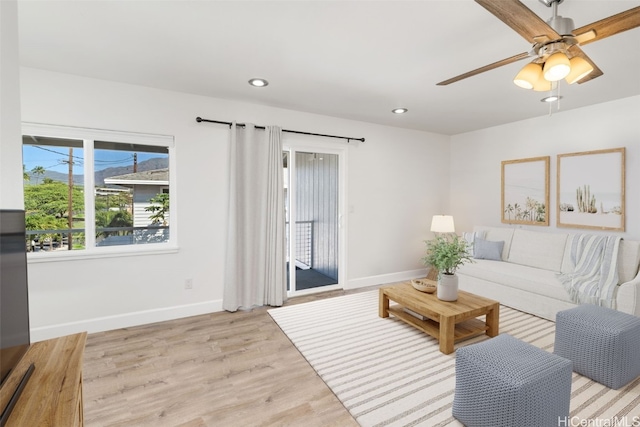 living room featuring ceiling fan and light hardwood / wood-style flooring