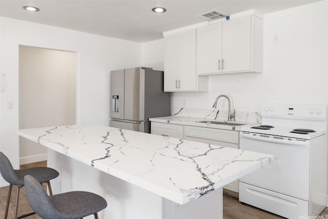 85-075 Waianae Valley Rd Unit B, Waianae, HI 96792 - kitchen featuring white range with electric cooktop, stainless steel fridge, a sink, a breakfast bar, and white cabinets