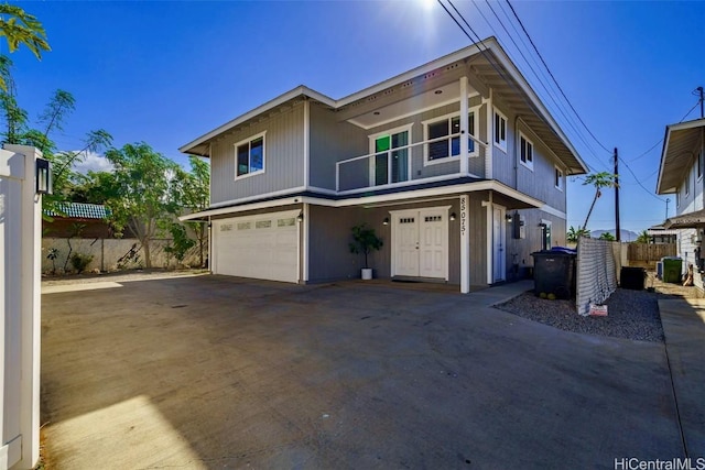 view of front of home with central AC, a balcony, and a garage