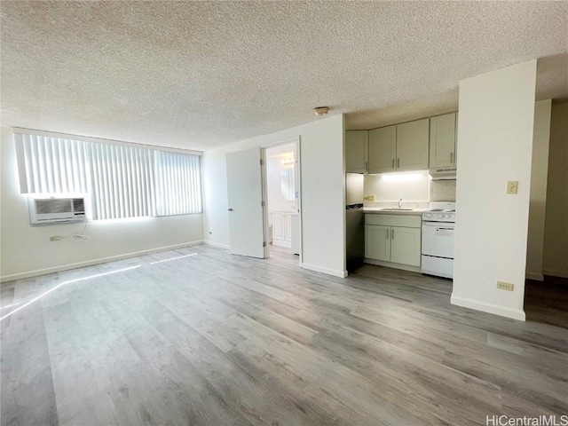 unfurnished living room featuring sink, light hardwood / wood-style flooring, and a textured ceiling